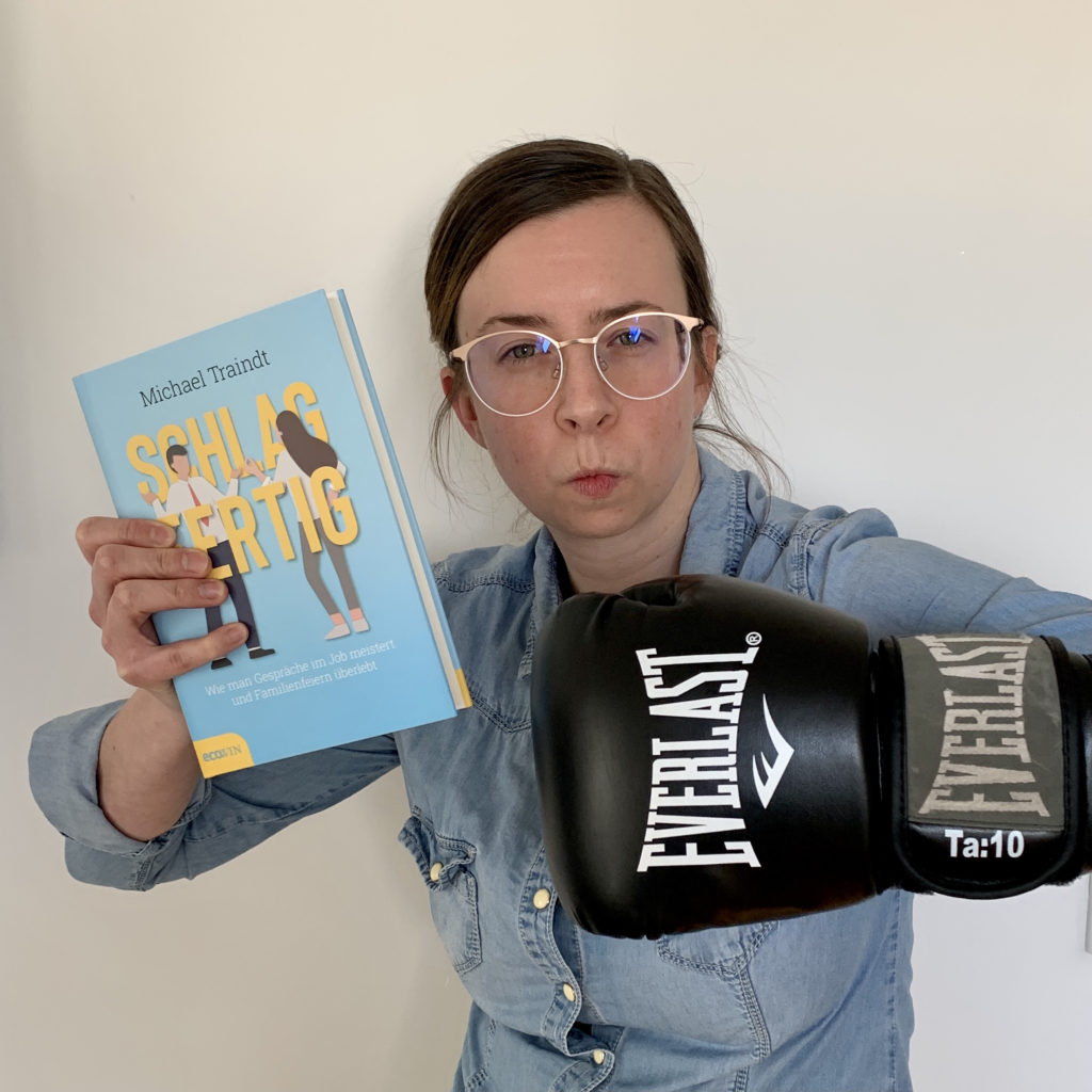 Bild: LovelyBooks Expertin Cornelia Absmanner in Action: mit dem Sachbuch "Schlagfertig" und einem Boxhandschuh